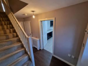 Una escalera en una casa con una puerta que conduce a una habitación en New Built Immaculate Condition en Rainham