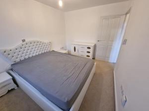 Habitación blanca con cama y puerta blanca en New Built Immaculate Condition en Rainham