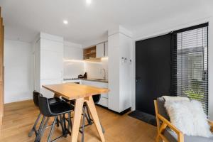 a kitchen and dining room with a wooden table and chairs at Adventure Riverside Retreat in Albert Town