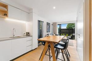 a kitchen and dining room with a wooden table and chairs at Adventure Riverside Retreat in Albert Town +5 photos
