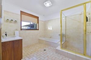 un bagno con vasca, lavandino e doccia di Spacious Family Home - Leafy Suburb & Pets Allowed a Orange Altre 24 foto