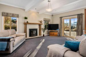 a living room with two couches and a tv at Paeroa View in Queenstown