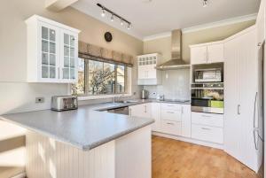 a kitchen with white cabinets and a counter top at Paeroa View in Queenstown