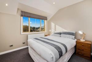 a bedroom with a large bed and a window at Paeroa View in Queenstown