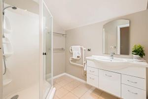 a white bathroom with a sink and a shower at Paeroa View in Queenstown +19 photos