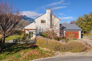 a large white house with a red garage at Paeroa View in Queenstown