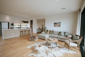 a living room with a couch and a table at Obelisk Dream with Spa in Wanaka