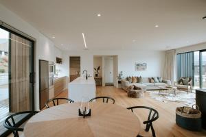 a kitchen and living room with a table and chairs at Obelisk Dream with Spa in Wanaka