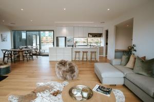 a living room with a couch and a table at Obelisk Dream with Spa in Wanaka +10 photos