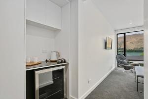 een witte woonkamer met een open haard en een stoel bij Lakefront Premier Studio in Wanaka