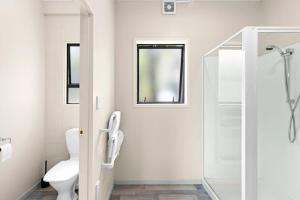 a bathroom with a toilet and a glass shower at Paradise in Pohara in Pohara