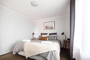 a bedroom with a large bed with white walls at Sharp Road - Comfy & Cosy near Hospital and Cadia in Orange