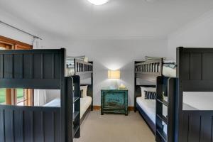 1 dormitorio con 4 literas y mesa en Snowline - Ultimate Getaway, Pool & Spa, Sleeps 16, en Canobolas