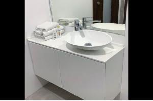 La salle de bains blanche est pourvue d'un lavabo et d'un miroir. dans l'établissement Apartments Artemus Karliva, à Izola