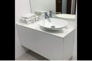 une salle de bain blanche avec un lavabo et un miroir dans l'établissement Apartments Artemus Karliva, à Izola