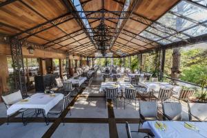 un restaurante con mesas blancas y sillas en un patio en Hotel Borkovac en Ruma