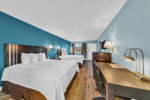 een hotelkamer met 2 bedden en een bureau bij Days Inn by Wyndham Carson City in Carson City