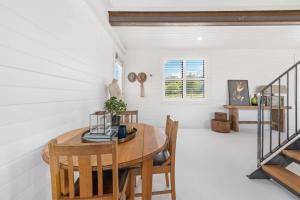 a dining room with a wooden table and chairs at Loft House - On Heifer Station Vineyard in Borenore