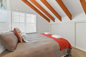 a bedroom with a large bed and a window at Peel St - Large Family Home Walk to CBD in Bathurst