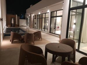 eine Lobby mit Stühlen, Tischen und Fenstern in der Unterkunft مساكن كيو in Dammam