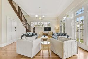 a living room with two white couches and a table at Kilarra House - Heritage Home on Byng St Sleeps 10 in Orange