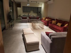 uma grande sala de estar com sofás e uma mesa em مساكن كيو em Dammam