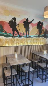 a wall with tables and chairs and a mural at ALBERGUE de Caldas de Reis URRACA in Caldas de Reis
