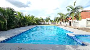 a large blue swimming pool with palm trees at Artem Apartments - Apartment 2 in Kitwe