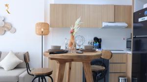 a kitchen with a wooden table with chairs and a small table with flowers on at Ivory Haven - Stylish 1BR Apartment in Oasis, Tranquil Stay Near Masdar Park in Abu Dhabi +32 photos