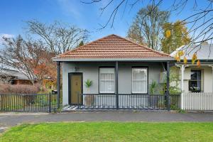 una piccola casa con una recinzione di fronte di Clinton Cottage 1860s Heritage Home Walk to CBD a Orange