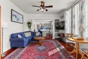 a living room with a blue couch and a rug at Beautiful Historic Mid City Home in New Orleans
