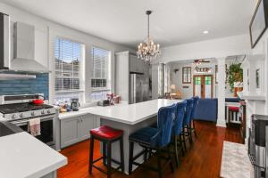 a kitchen with a white counter and blue chairs at Beautiful Historic Mid City Home in New Orleans