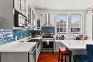 ニューオーリンズにあるBeautiful Historic Mid City Homeの白いカウンターとコンロ付きオーブンのあるキッチン +21枚の写真