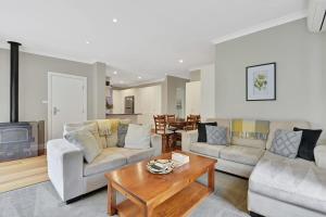 Sala de estar con 2 sofás y mesa de centro en Kinross Cottage Close to CBD Comfy & Convenient en Orange