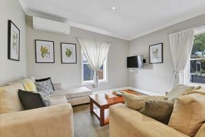 Sala de estar con 2 sofás y mesa en Kinross Cottage Close to CBD Comfy & Convenient en Orange