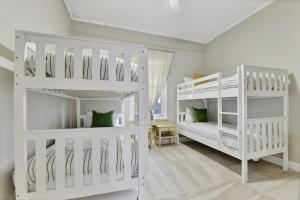 オレンジにあるKinross Cottage Close to CBD Comfy & Convenientの白い部屋の二段ベッド2台