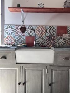 a kitchen counter with a sink and tiles on the wall at Appartement de charme in Vitrac +37 photos