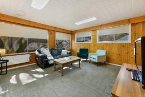 ein Wohnzimmer mit einer Couch, einem Tisch und einem Fernseher in der Unterkunft Collwood Cottage Cosy & Free Wifi in Orange