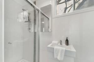 ein weißes Badezimmer mit Dusche und Waschbecken in der Unterkunft Collwood Cottage Cosy & Free Wifi in Orange + 16 Fotos