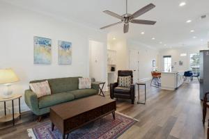 een woonkamer met een groene bank en een plafondventilator bij Stunning Luxury Home 2 Blocks From Streetcar in New Orleans