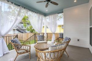 a porch with chairs and a ceiling fan at Stunning Luxury Home 2 Blocks From Streetcar in New Orleans