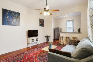 a living room with a couch and a tv at Urban 3 bedroom Local Art Filled Frenchman Oasis in New Orleans