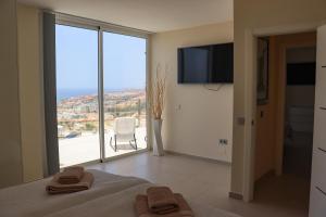 a bedroom with a large window with a view at Azure Sky Villa - Panoramic ocean view, luxury, San Eugenio in Adeje