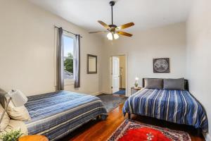 a bedroom with a bed and a ceiling fan at Urban 3 bedroom Local Art Filled Frenchman Oasis in New Orleans