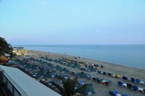 una playa con un montón de sombrillas y sillas en Panorama Hotel en Paralia Katerinis