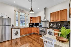 a kitchen with white appliances and wooden cabinets at Edwina Suite II - Fireplace, Elegant Heritage Home in Orange