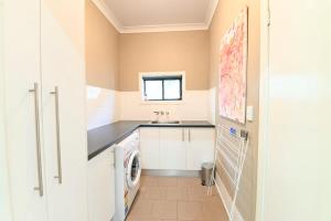 a laundry room with a sink and a washing machine at Sterling House Spacious Deck BBQ Pet Friendly in Dubbo +18 photos