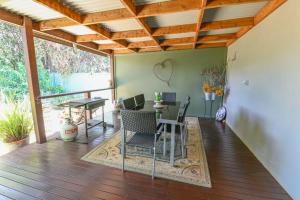 a patio with a table and chairs on a deck at Sterling House Spacious Deck BBQ Pet Friendly in Dubbo