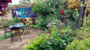 a garden with a table and chairs and flowers at Casaca in Concepción de Ataco