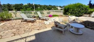 a patio with chairs and a table and a fence at Racconto di Puglia - Selva di Fasano in Selva di Fasano